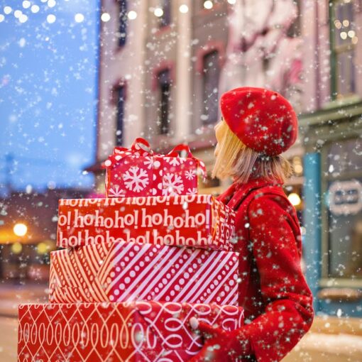woman holding three red christmas presents boxes