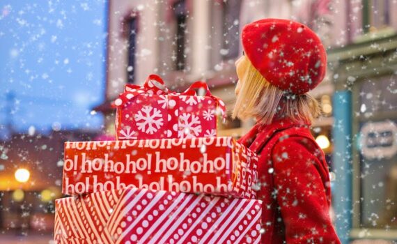woman holding three red christmas presents boxes