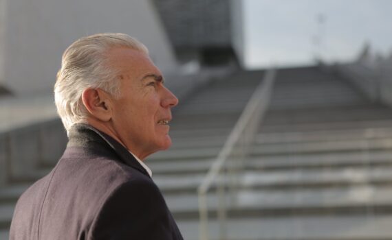 serious elderly gentleman on stone stairs in city