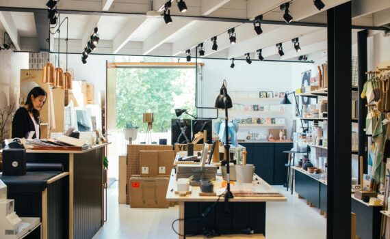 young ethnic female employee standing at counter in creative gift shop