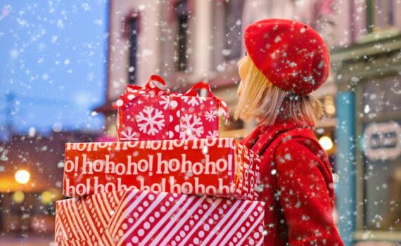 woman holding three red christmas presents boxes